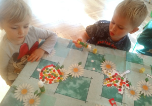 dzieci wyklejają kontury listków kolorowymi kółeczkami