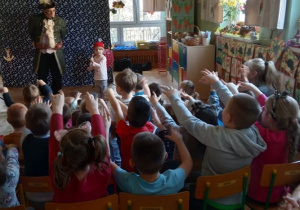 Dzieci i pan iluzjonista wspólnie "czarują".