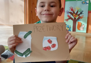 Chłopiec pokazuje swoją pracę pt. "Przetwory".
