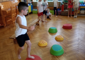 Chłopiec przechodzi po kamieniach sensorycznych.