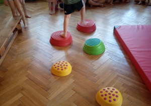Dzieci przechodzą po kamieniach sensorycznych.
