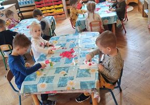 dzieci wyklejają serduszka dla rodziców
