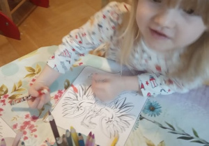 Dziewczynka koloruje godło.