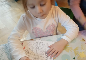 Dziewczynka koloruje godło.