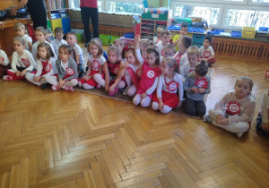 Dzieci siedzą na dywanie