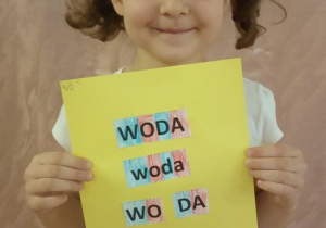 Dziewczynka pokazuje swą pracę.