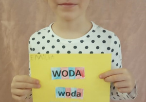 Dziewczynka pokazuje swą pracę.