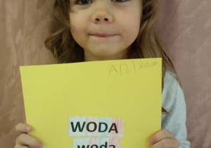 Dziewczynka pokazuje swą pracę.