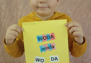 Chłopiec pokazuje swą pracę.