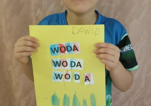 Chłopiec pokazuje swą pracę.