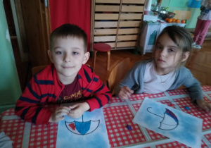 Dziecko wykleja plasteliną kontur parasolki