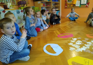 Dzieci siedzą na podłodze