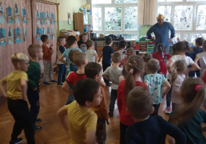 Dzieci śpiewają i tańczą razem z panem prowadzącym zabawy muzyczne.