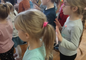 Dzieci patrzą na pana prowadzącego zabawy i naśladują jego ruchy.