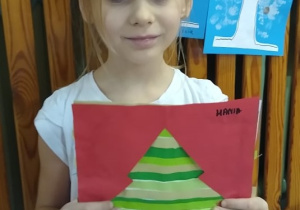 Dziewczynka pokazuje swoją pracę.