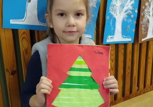 Dziewczynka pokazuje swoją pracę.