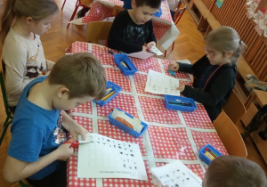 Dzieci wycinają brakujące obrazki potrzebne do dopełnienia sekwencji.