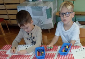 Dzieci wycinają brakujące obrazki potrzebne do dopełnienia sekwencji.