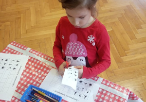 Dziecko wycina brakujące obrazki potrzebne do dopełnienia sekwencji.