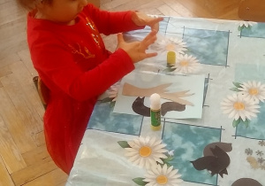 dzieci wyklejają ptaszki z papieru i śnieg z waty