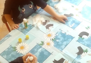 dzieci wyklejają ptaszki z papieru i śnieg z waty