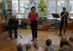 Pani prowadząca audycję przedstawia muzyków.