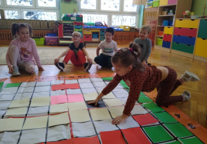 Dziecko układa kartkę na macie do kodowania