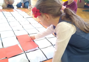 Dziecko układa kartkę na macie do kodowania