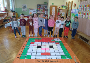 Dzieci pozują z matą do kodowania