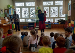 Dzieci słuchają pani, która prowadzi audycję muzyczną.