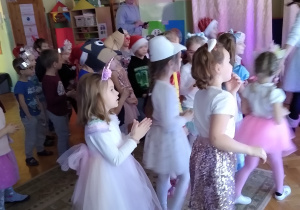 Dzieci bawią się przy muzyce z animatorką