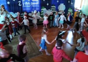 Dzieci bawią się przy muzyce z animatorką