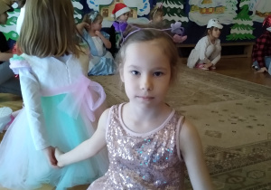 Dziewczynka pozuje do zdjęcia w sukience z cekinami