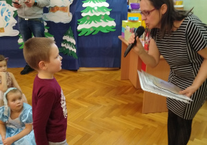 Nauczycielka wręcza chłopcu nagrodę i dyplom