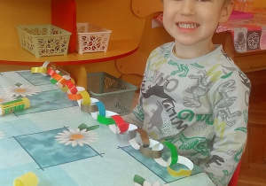 dzieci sklejają paski z kolorowego papieru