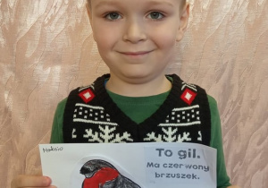 Chłopiec pokazuje swą pracę.