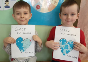 Chłopcy prezentują swoje serduszka dla Dziadków.