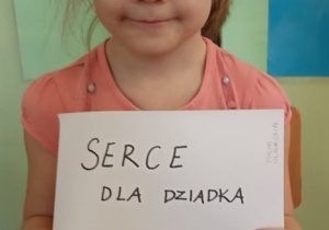 Dziewczynka prezentuje swoje serduszko dla Dziadka.