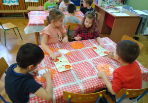 Dzieci pracują przy stolikach.