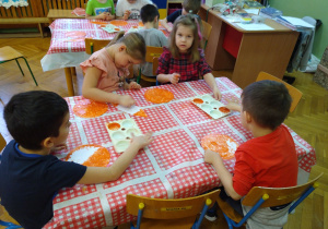 Dzieci pracują przy stolikach.