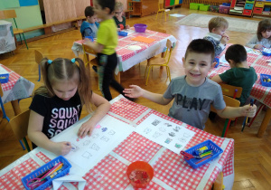 Dzieci pracują przy stolikach