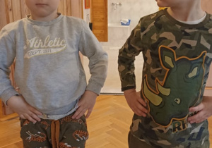 dzieci stoją i trzymają się pod boczki