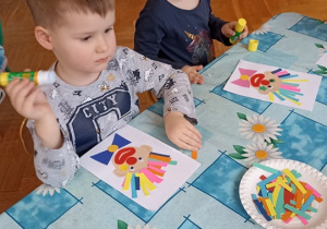chłopiec wykleja paskami kolorowymi włosy klauna