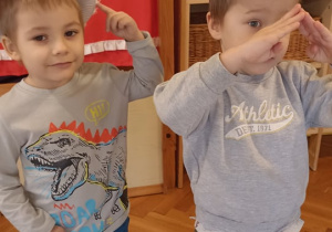dzieci prezentują czpki karnawałowe wykonane z talerzyków papierowych
