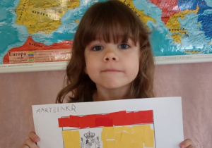 Dziewczynka prezentuje flagę Hiszpanii.