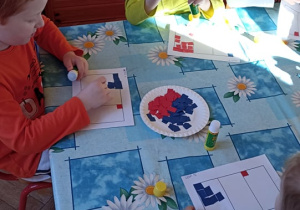 dzieci wyklejają flagę Francji papierwm kolorowym