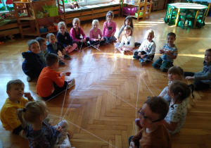 Dzieci siedzą na podłodze