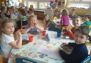 Dzieci zjadają przygotowana przez siebie pizzę
