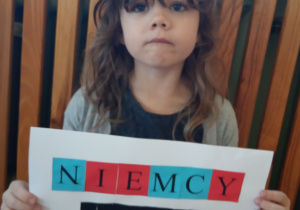 Dziewczynka prezentuje swą pracę.