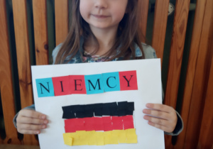 Dziewczynka prezentuje swą pracę.